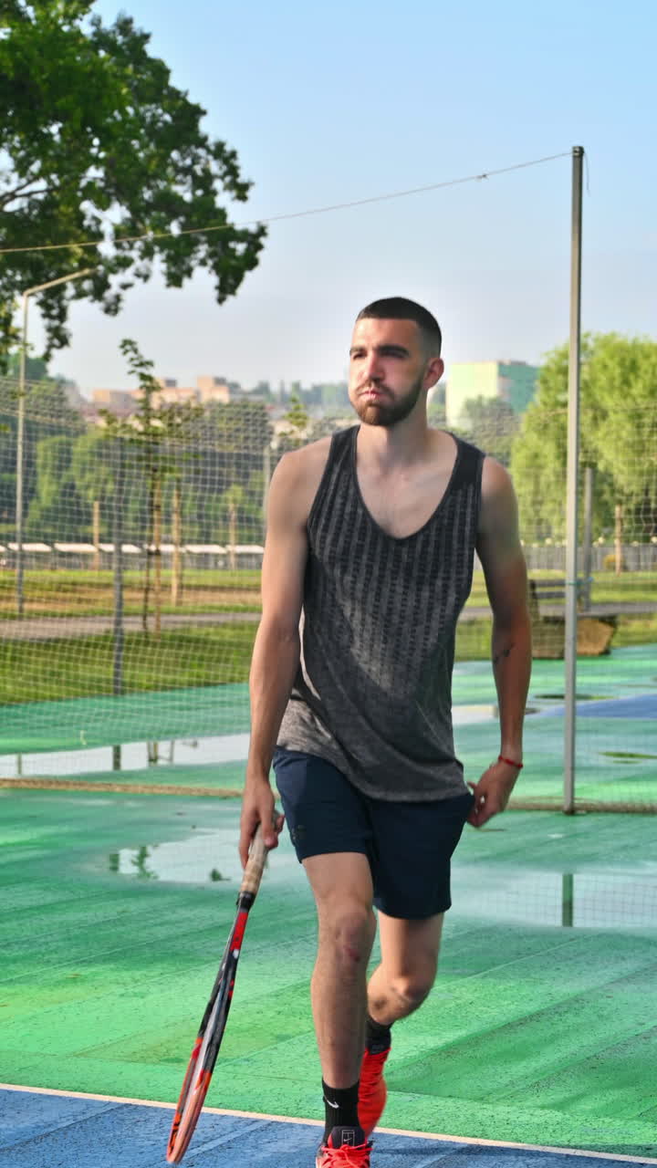 Man playing tennis at sunrise, after rain. Vertical