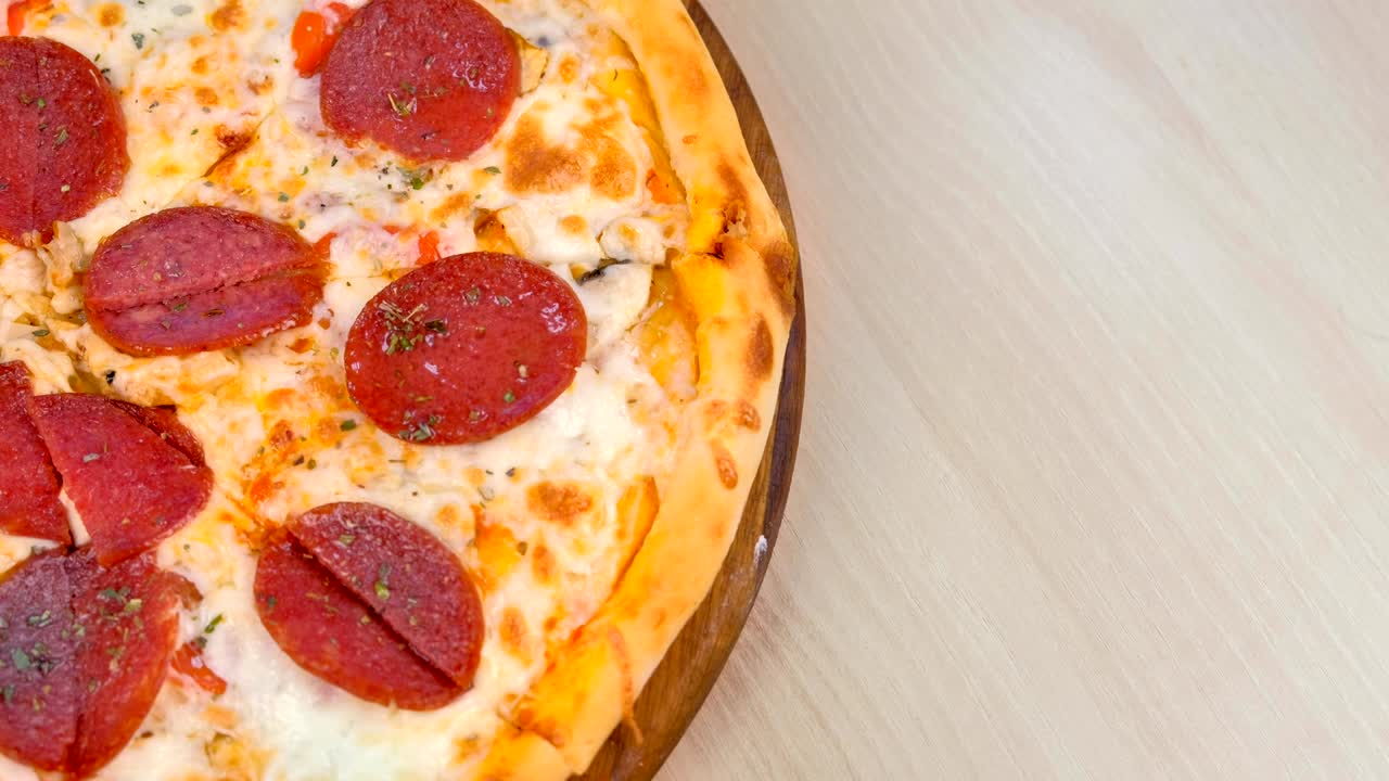 테이블 위의 나무판 위에 살라미 피자를 잘라내는 터.