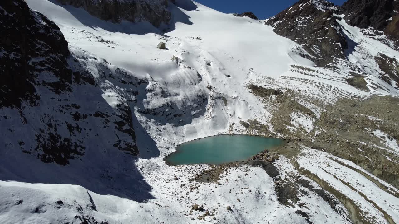 vista aérea de la laguna charquini, una laguna esmeralda en las montañas alpinas
