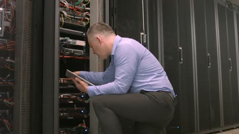 technician using tablet pc while analysing server