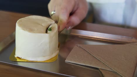 Close-up-shot-of-a-woman's-hands-cutting-chocolate-cake-with-fork-on-restaurant-table