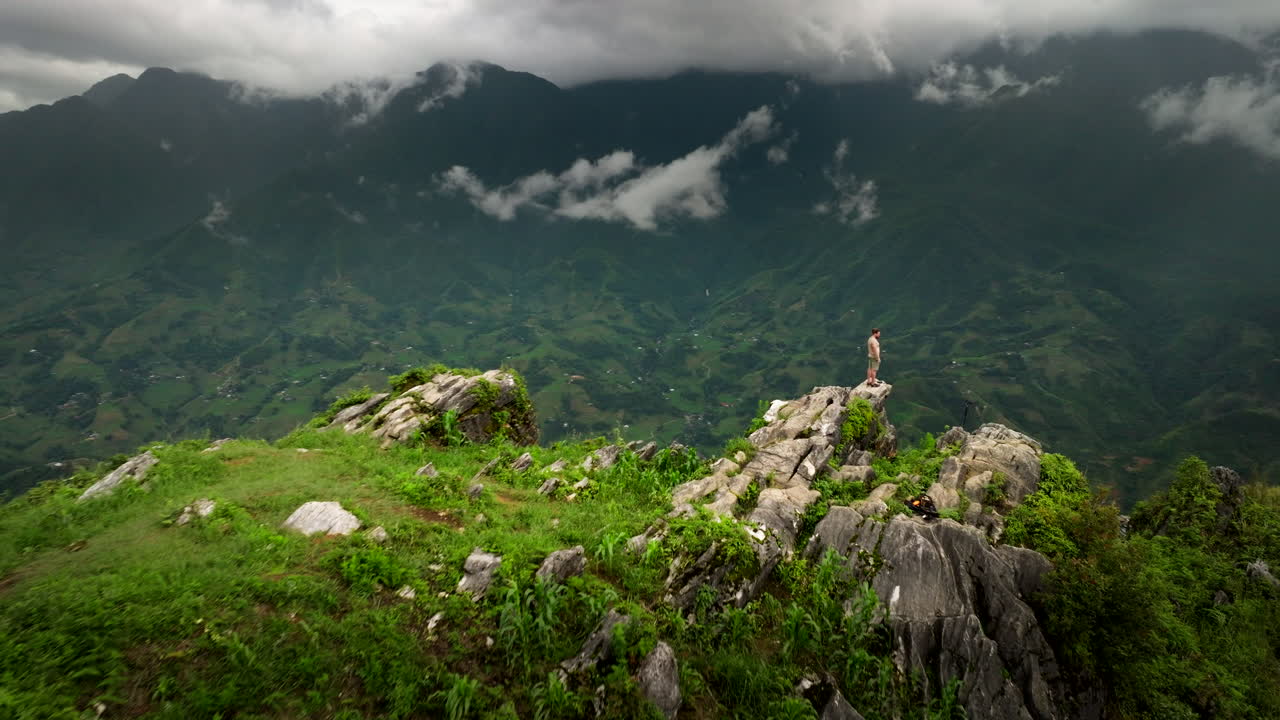 Aerial view of man atop Dragon Jaw Ham Rong mountain overlooking Sapa in Vietnam