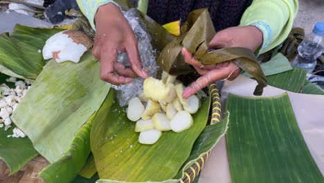 the process of preparing delicious lupis cake will be wrapped in fresh banana leaves directly from traditional street vendors