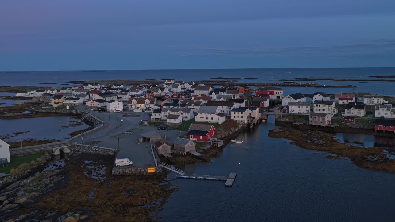Warmes Morgenlicht streift die Holzdächer eines Dorfes in Norwegen, Drohnenaufnahme.