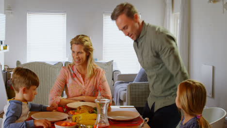 Front-view-of-young-Caucasian-family-having-food-at-dining-table-in-a-comfortable-home-4k