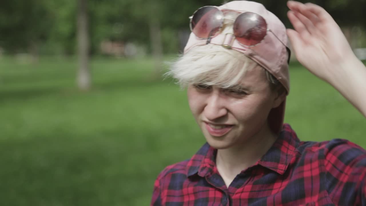 симпатичный подросток ждет кого-то в парке в солнечный день - снимок крупным планом