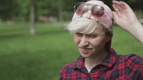 un adolescente guapo esperando a alguien en el parque en un día soleado - primer plano