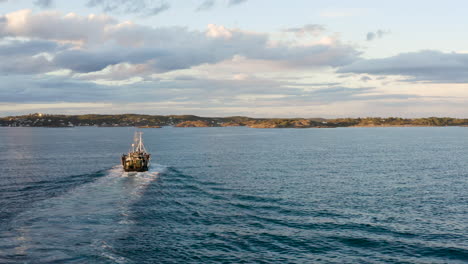 arrastrero de pesca navegando a lo largo del estrecho de skagerrak con retrolavado en la superficie cerca de arendal en noruega
