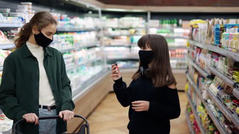 moms allows to buy a sweet to her teen daughter in the supermarket