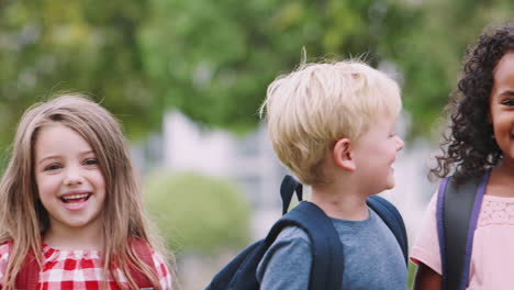 portrait of excited elementary school pupils on playing field at break time