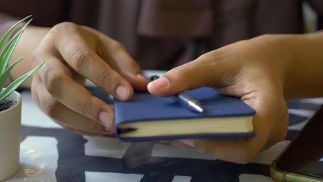 person holding a notebook and pen