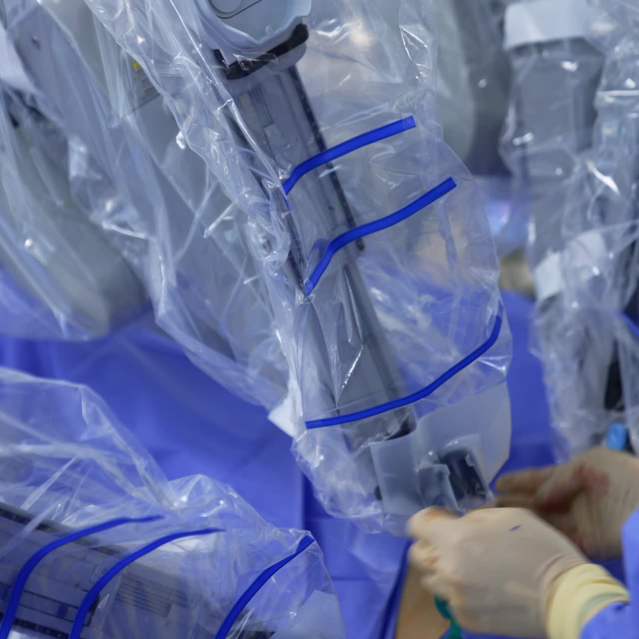 Female medic taking the robotic arm of equipment and pulling it down. Assistant dealing with surgeon robot covered in plastic. Close up