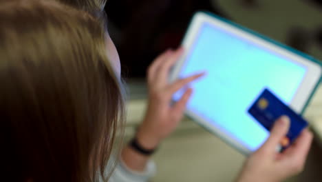 woman paying online using pad and bank card