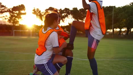 Female-soccer-players-cheering-with-arms-in-the-air-on-soccer-field.-4k