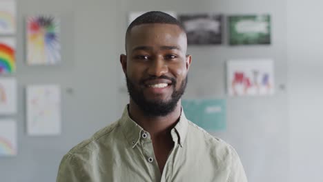 Video-of-happy-african-american-male-teacher-standing-in-classroom