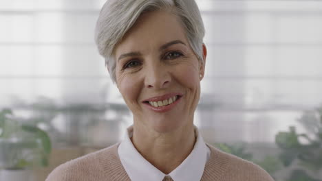 Retrato-De-Una-Sofisticada-Mujer-De-Negocios-Madura-Sonriendo-Mirando-La-Cámara-Disfrutando-De-Un-Estilo-De-Vida-Exitoso-Mujer-Mayor-Vistiendo-Jersey-En-El-Fondo-Del-Espacio-De-Trabajo-De-Oficina