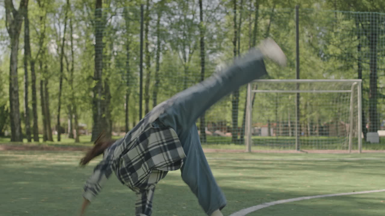 Young girl doing cartwheels in a park