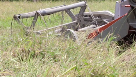 granjero que opera un campo de arroz de máquina cosechadora de arroz en una aldea rural en sri lanka en medio del día soleado y caluroso