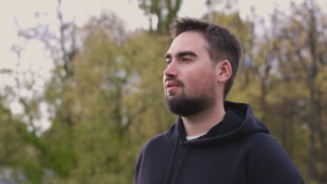 bearded man breathing fresh air standing in the park in the morning