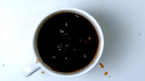 cubo de azúcar cayendo en una taza de café