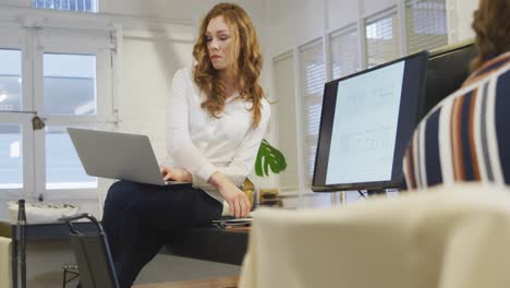 Businesswoman-working-on-laptop-in-modern-office