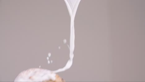 chocolate chip cookie flying through stream of milk splashing in slow motion 4k with gray backdrop