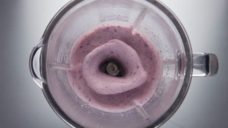 closeup berry cocktail mixing in blender bowl super slow motion top view.