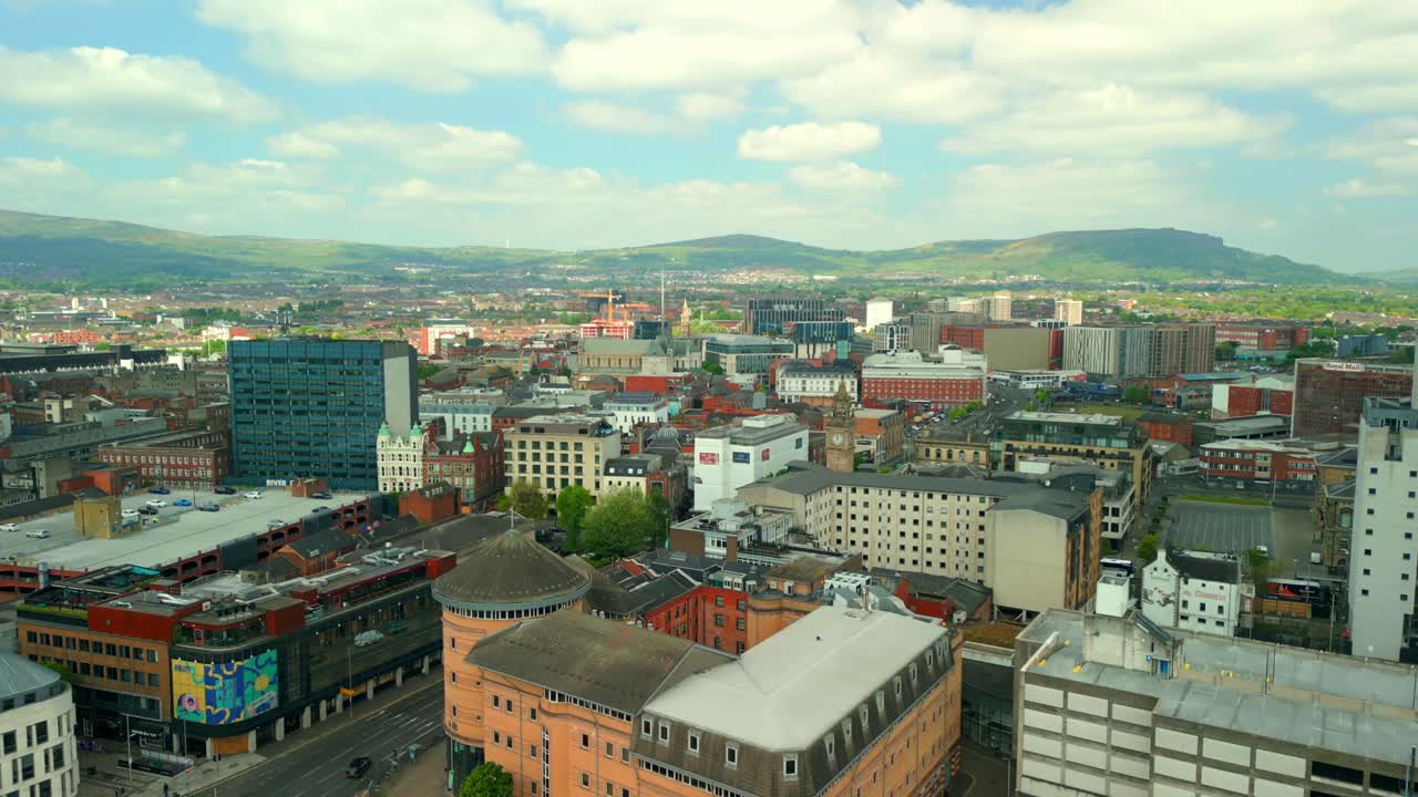 Wide, reversing aerial video of Belfast City Centre and the surrounding area in Northern Ireland, UK on a bright and sunny day. Filmed in 4K, 60FPS and in Rec709 Color.