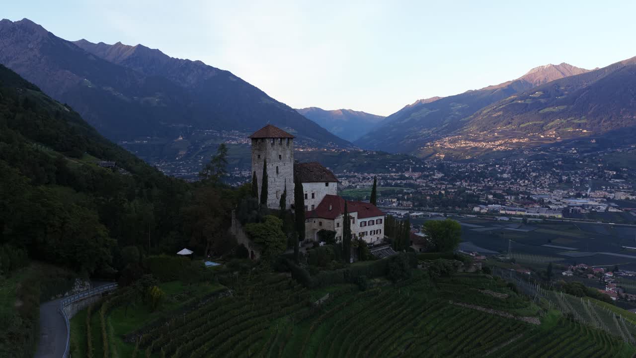 Schloss Lebenberg, Lebenberg Castle near the village of Tscherms in South Tyrol, Italy. On a moraine hill in front of the slopes of the Marlinger Berg. Dusk. Aerial video