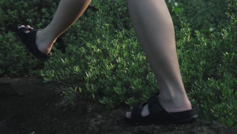 Close-up-shot-of-girl-walking-on-the-rocks-during-trekking,-slow-motion