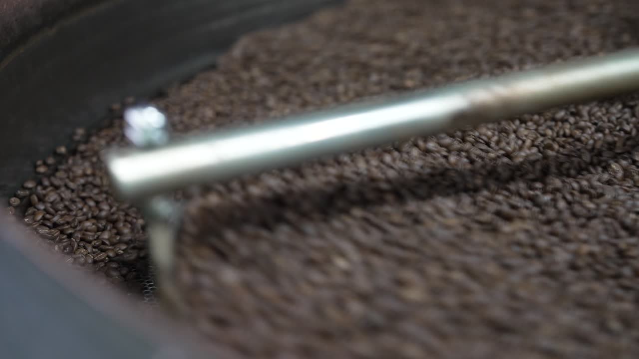Fresh roast beans stir across the cooling tray with visible texture and movement