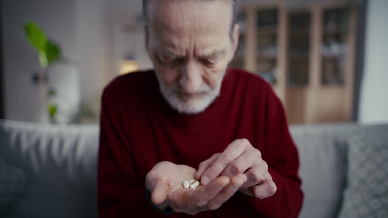 Uomo anziano che assume i farmaci quotidiani dalla mano