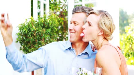 smiling couple taking selfie during lunch