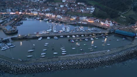 Toma-Aérea-De-Barcos-Estacionados-En-El-Puerto-De-Scarborough-Durante-La-Noche-En-Inglaterra