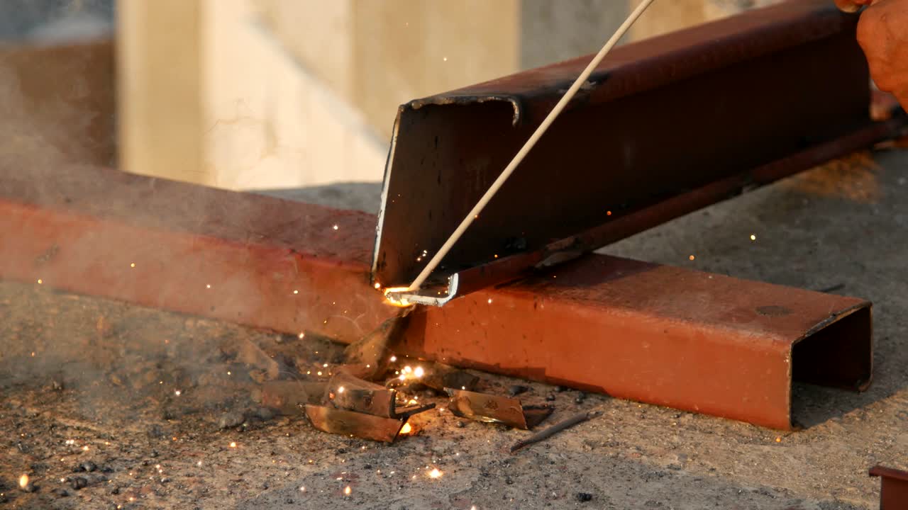 Taglio di un profilato d'acciaio (profilato a C in acciaio) con smerigliatrice. Scintille durante la smerigliatura del ferro