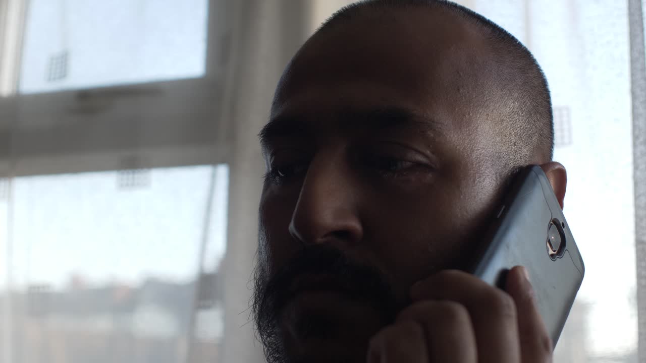 Adult Asian Male Holding Phone To Ear Indoors