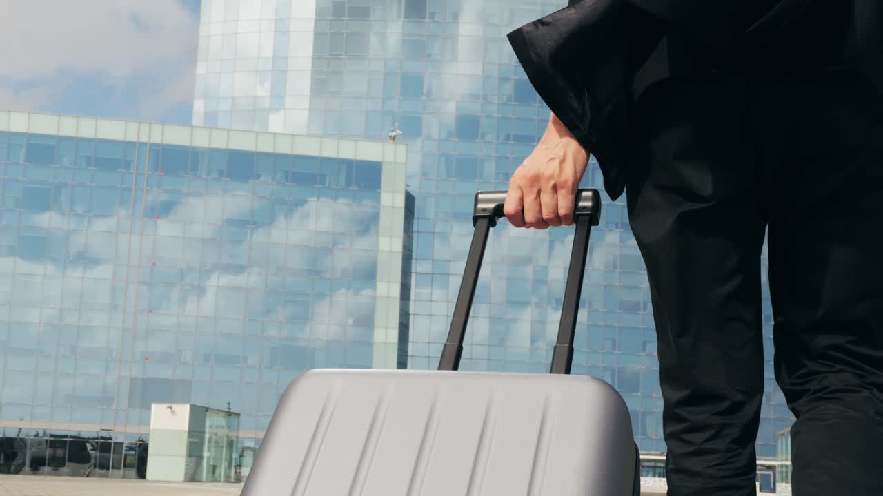 Hombre turista con maleta en España, un viajero con equipaje y chaqueta de traje en una calle de negocios yendo a un hotel, oficina o terminal de aeropuerto, disfrutando del ambiente vibrante