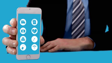 sección media de un hombre de negocios que muestra un teléfono móvil con iconos