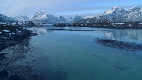 A-beautiful-snow-covered-shoreline-amidst-fjords-north-of-the-Arctic-Circle-in-Lofoten-Islands-Norway-2