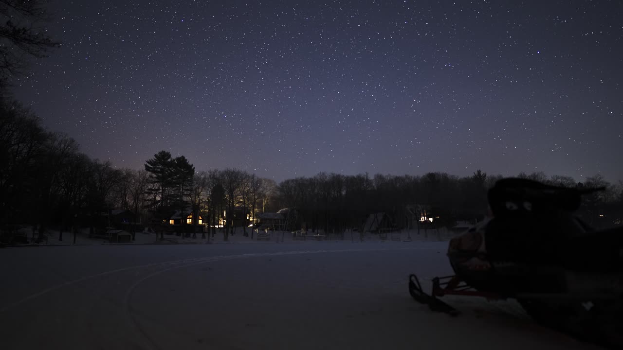 Night sky stars timelapse in winter snow cabin scene