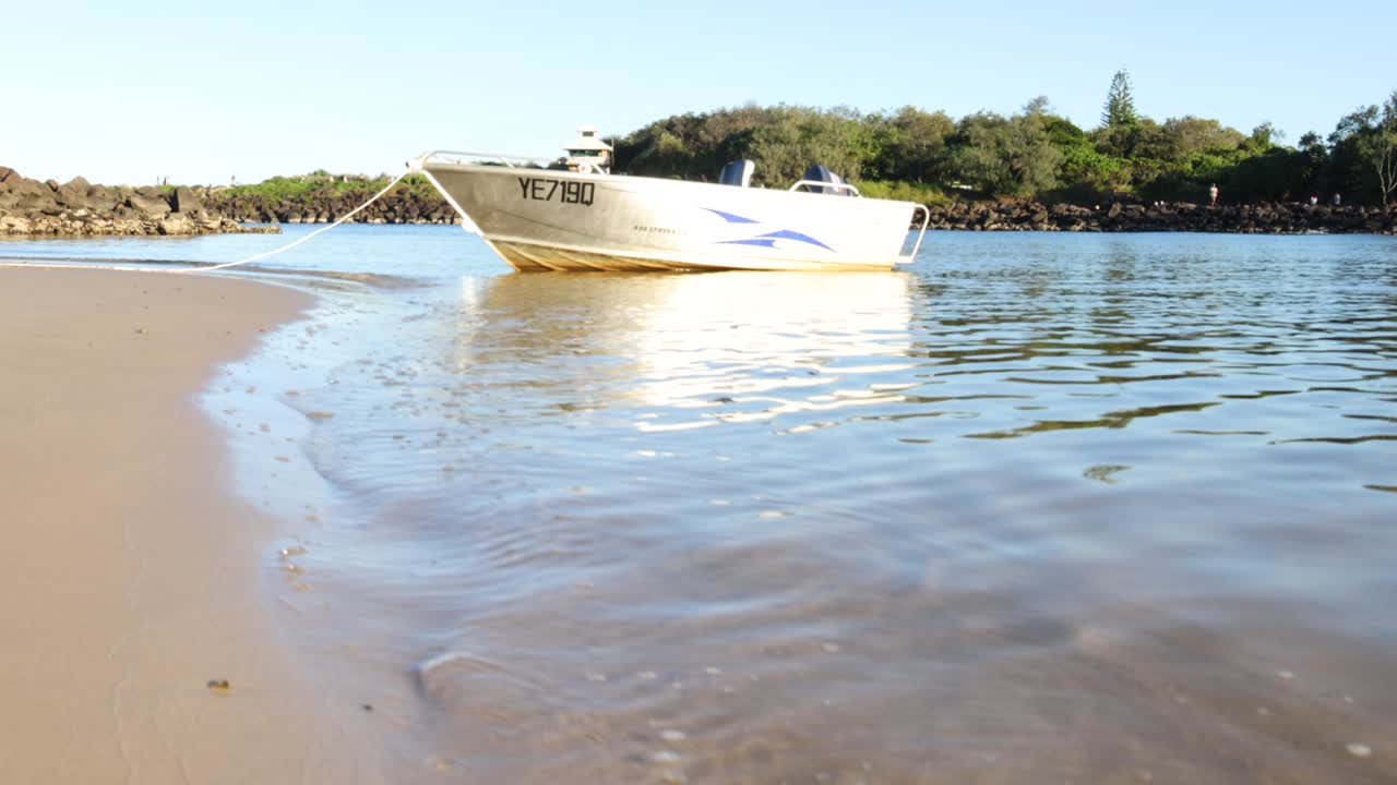 un pequeño barco se acerca gradualmente y aterriza en una playa