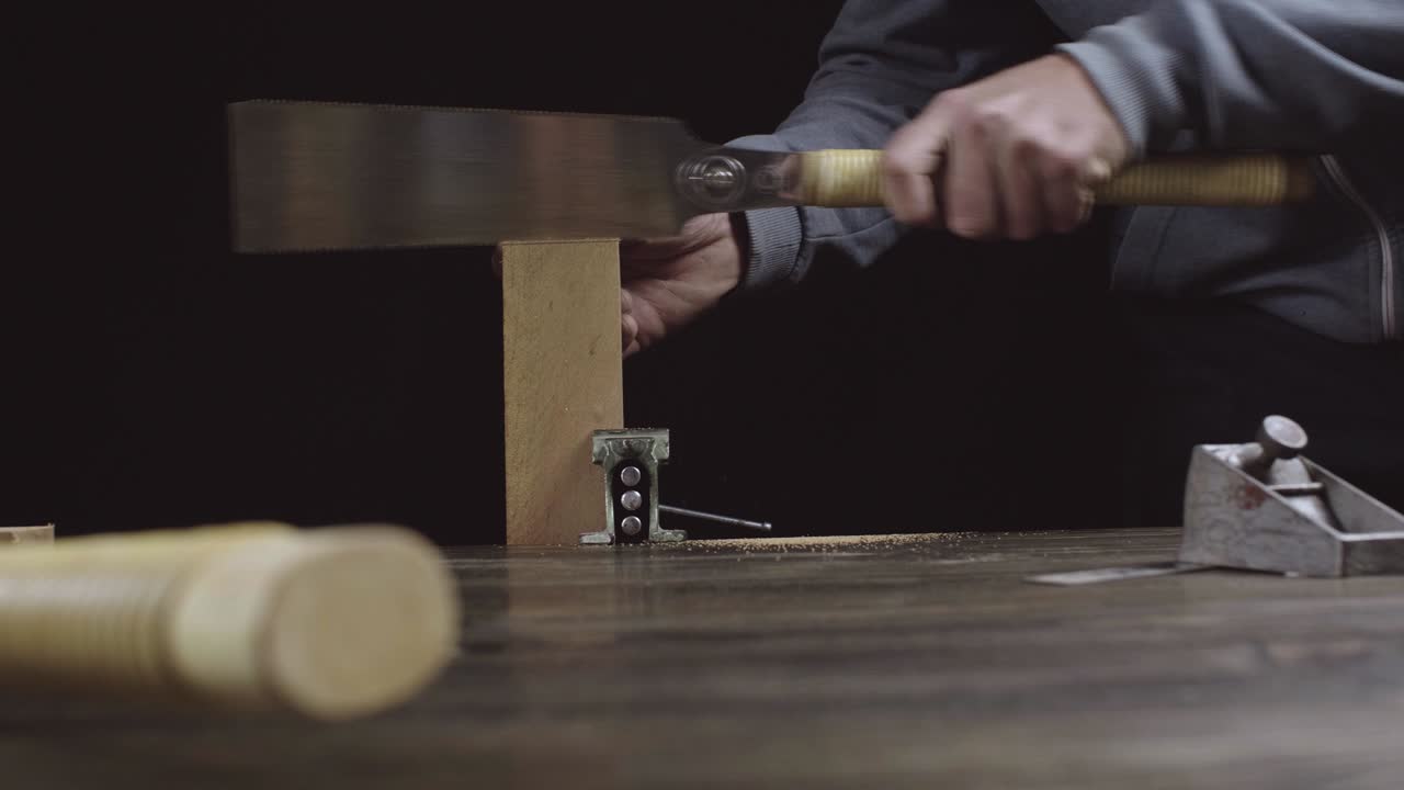 un artesano de madera cortando un detalle de madera para hacer un peine de barba. carpintero hace un peine de madera hecho a mano.. cine 4k video