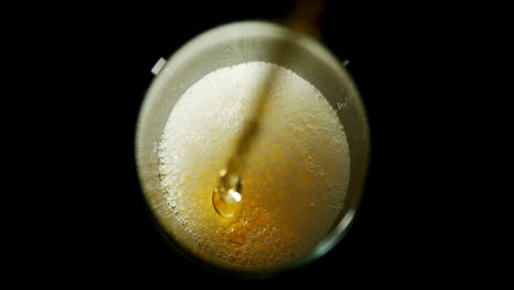 beer poured in glass against black background 4k