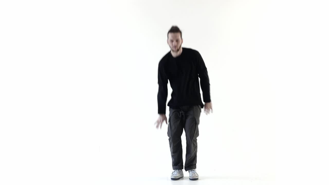 Junger Mann tanzt dynamischen Hip-Hop auf weißem Hintergrund