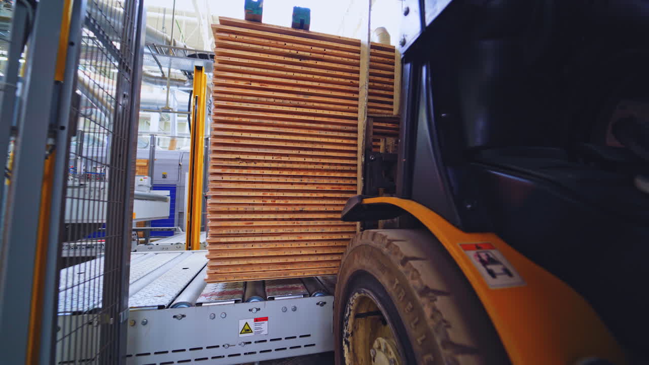 Forklift transporting wooden panels in a factory