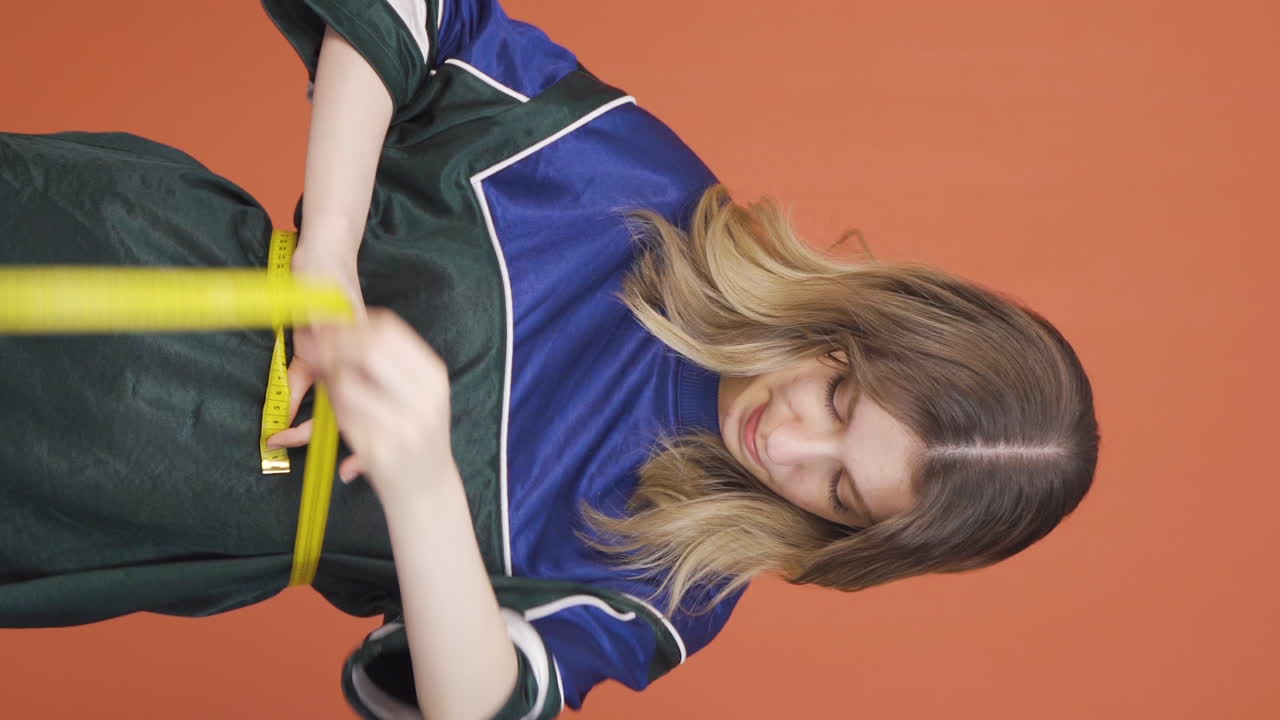 자신의 몸무게에 만족하는 젊은 여성의 수직 비디오.