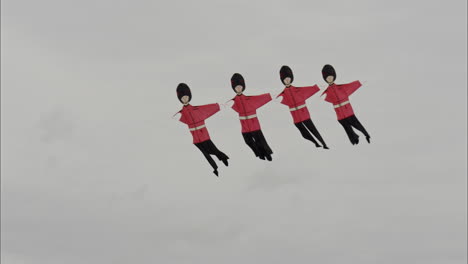 a kite in the shape of the kings guard soldiers dances in the wind