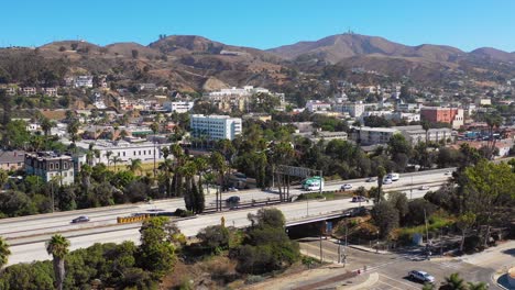 a drone aerial of southern california beach town of ventura california with freeway foreground and mountains background 3