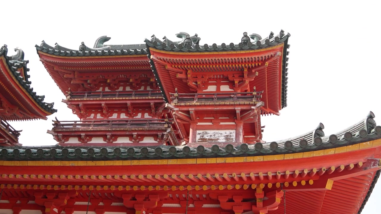 Arkitektonisk nærbillede af den cinnoberrøde taglinje og øvre strukturer af Heian-jingu-helligdommen, der fremhæver traditionelt Shinto-design og levende røde detaljer i Kyoto, Japan
