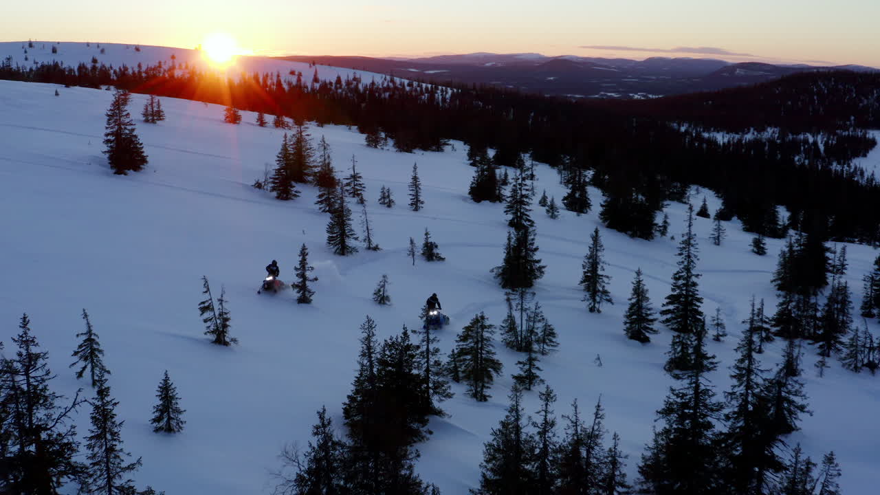 motos de nieve que viajan a través de la nevada laponia desierto de bosques alpinos congelados al atardecer